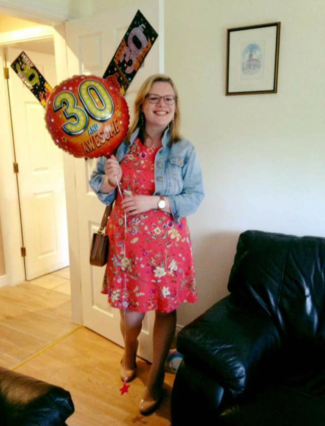 woman wearing a dress and holding balloons on her 30th birthday