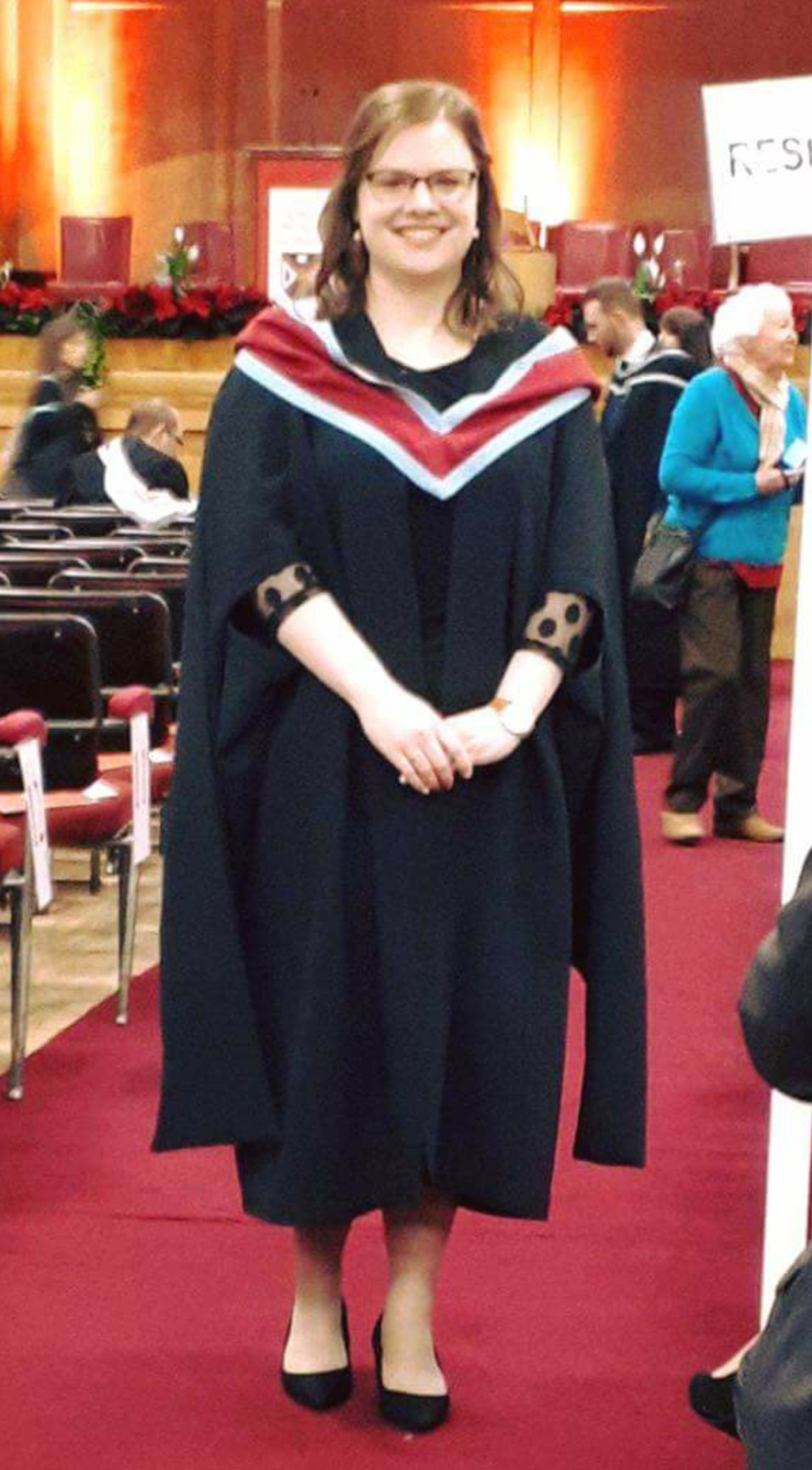 woman wearing a gown at her masters graduation ceremony