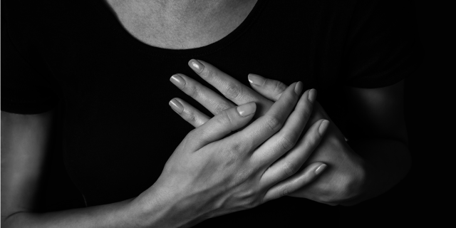 Woman with hands over her chest