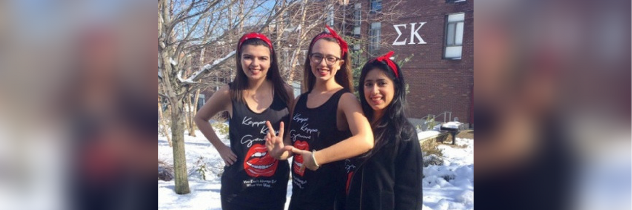 three sorority girls standing outside in the snow wearing matching clothes