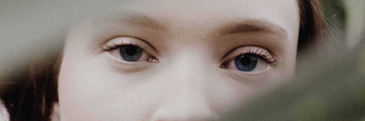 What I Want Someone Struggling With Self-Harm to Know womans eyes looking through branches