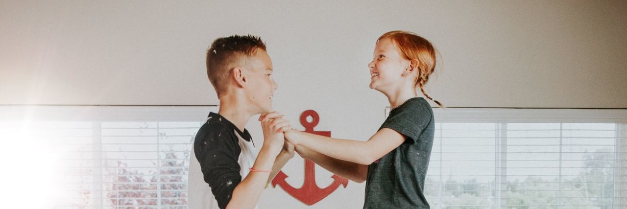 I'm Autistic & My Brother's Not. This Is What Our Relationship's Like brother and sister jumping on a bed