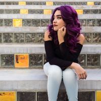 woman with purple hair sitting on steps