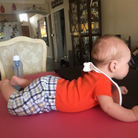 Jessica's son on yoga mats on the table for tummy time.