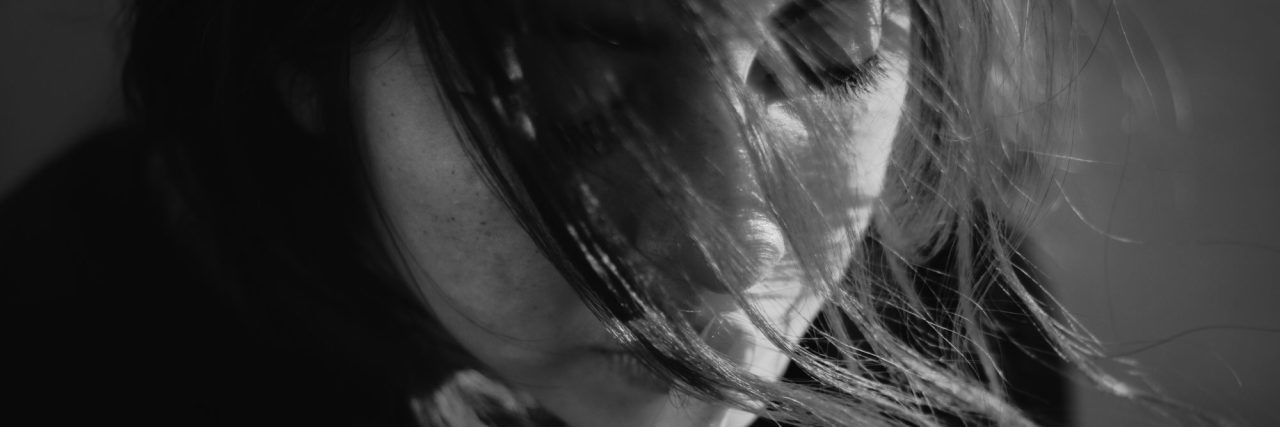 The Question I Hate Being Asked as Someone With Bipolar Disorder black and white photo of young woman with fingers to lips