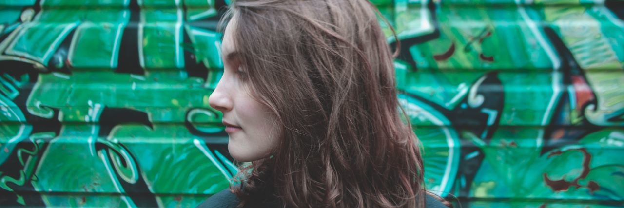5 Things I'm Doing as I Start a New Year in Eating Disorder Recovery woman stands in front of graffiti wall