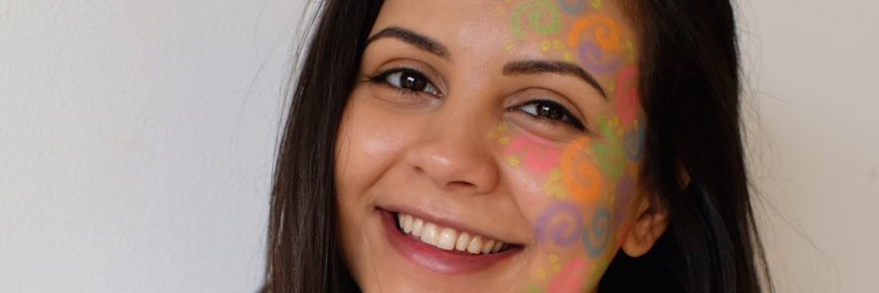 How to Advocate for Your Disease on Rare Disease Day the author with "rare" colors painted on her face for rare disease day