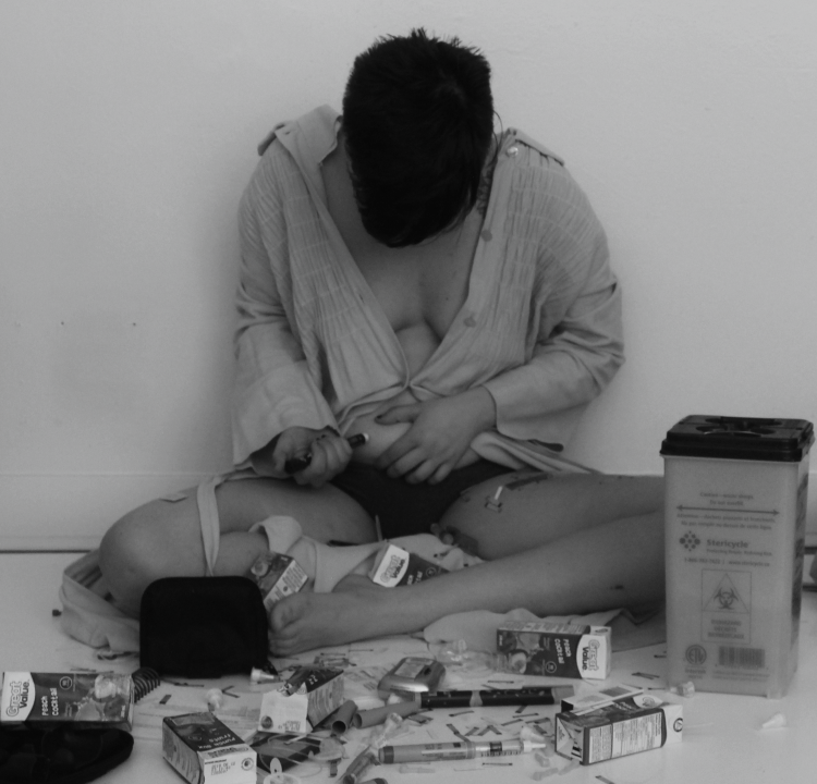 black and white photo of a woman sitting on the ground surrounded by medical equipment