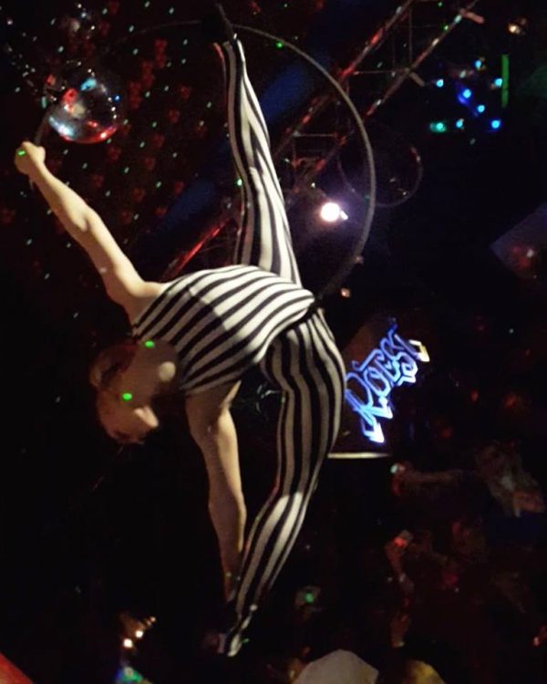 woman in black and white striped outfit performing aerial hooping