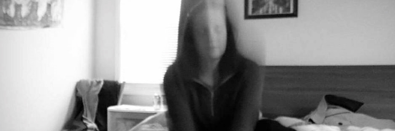 I Have BPD and I Can't Remember What I Look Like The contributor sitting in bed, her image blurry