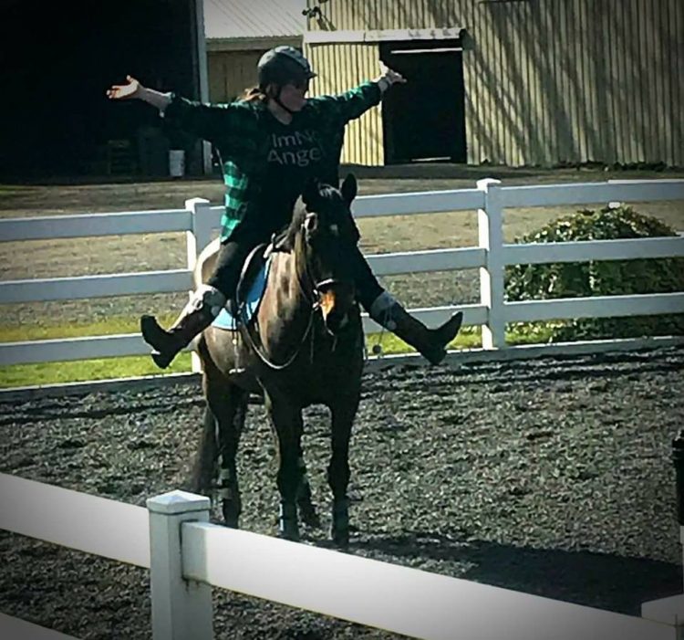 the author riding a horse with her arms in the air