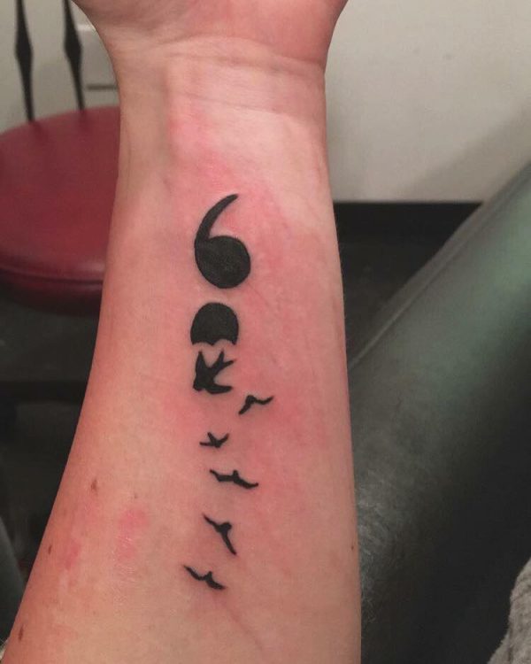 A tattoo of a semicolon turning into birds