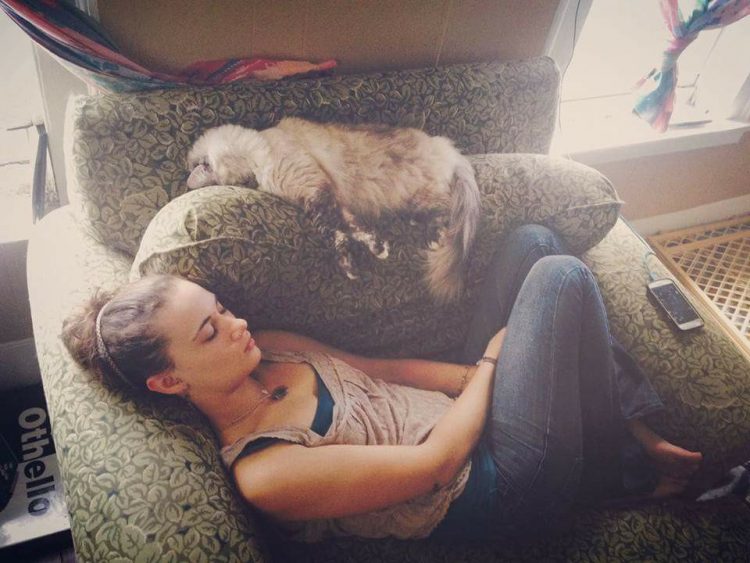 woman sleeping on couch next to dog