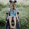 Cute girl with pigtails sitting on her wheelchair and smiling