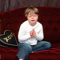Boy with Down syndrome sitting on couch