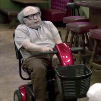 danny devito sitting in a motorized scooter and looking extremely pale