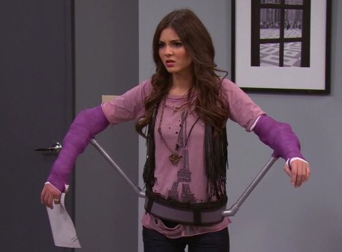 victoria justice wearing purple arm casts on both her arms, supported by metal rods
