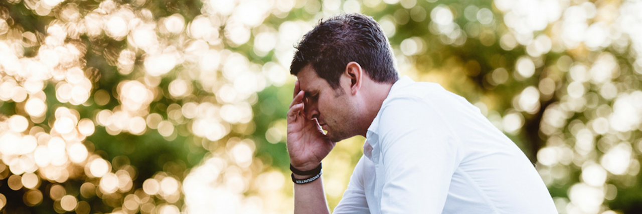 What to Know If You're Newly Diagnosed With Chronic Illness man sitting outside with text that says 'living with chronic illness: 5 tips for the newly diagnosed