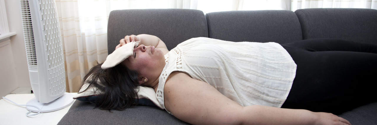 20 'Hacks' That Can Make Sleeping With Fibromyalgia Easier person sleeping with an ice pack on their head and a fan