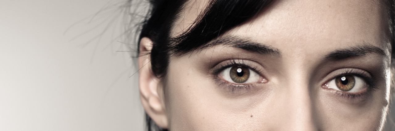 Worrying About Having Children With Fibromyalgia portrait of a woman with dark hair in a ponytail and frowning