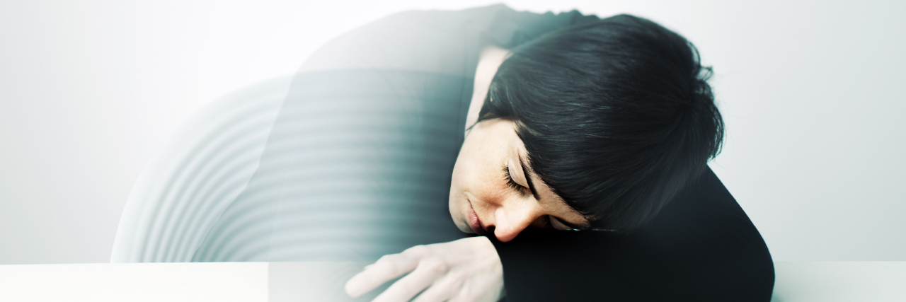 10 Reasons Why Anxiety Sucks... the Life Out of Me Young woman having a nap on a table. She's half transparent because she's at half way from her dreams.