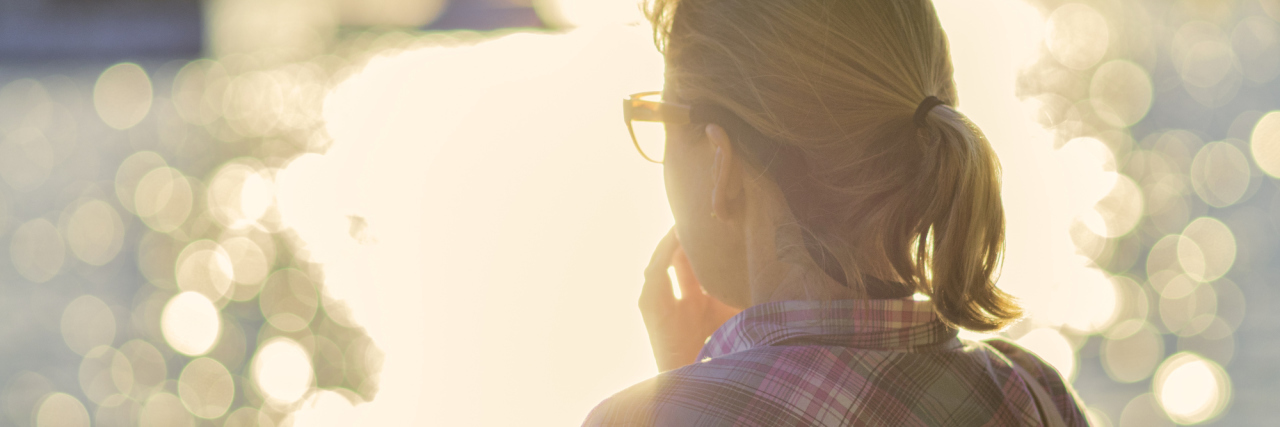 Why I'm Grateful to Fibromyalgia woman in a plaid shirt with a blonde ponytail looking at the reflection of light on a lake