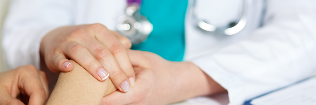 To the Doctor Who Believed My Illnesses Are Real doctor holding patient's hand in support