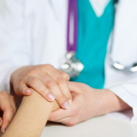 doctor holding patient's hand in support