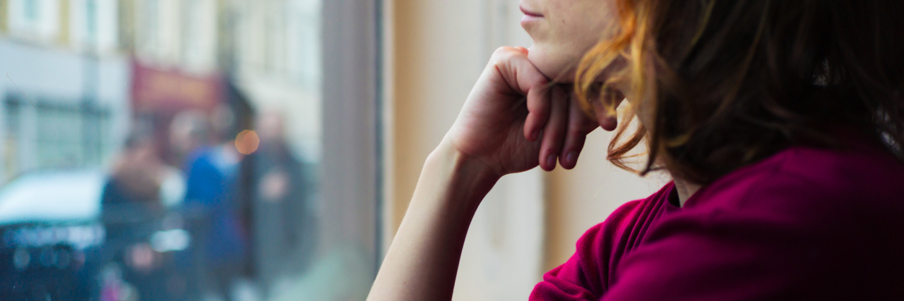 How My Chronic Pain Affects My Everyday Life A young woman looking outside a window.