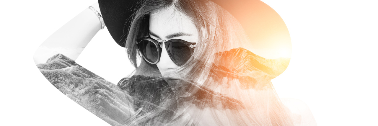 double exposure of a woman wearing a hat and sunglasses and a sunny mountain range