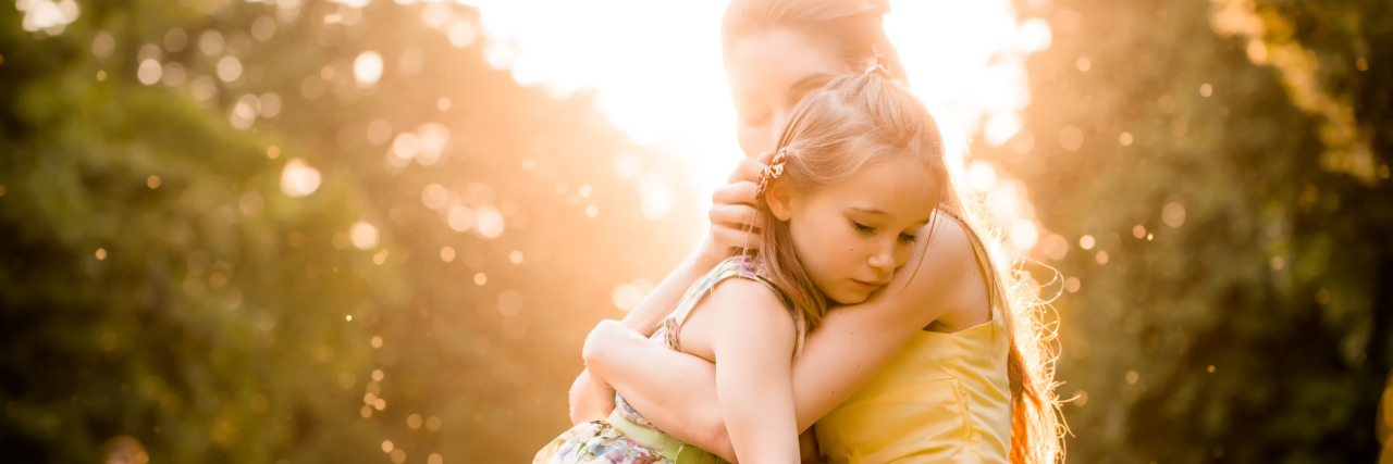 Being a Parent With Depression to a Child on the Autism Spectrum Mother holding daughter in bright sunlight meadow