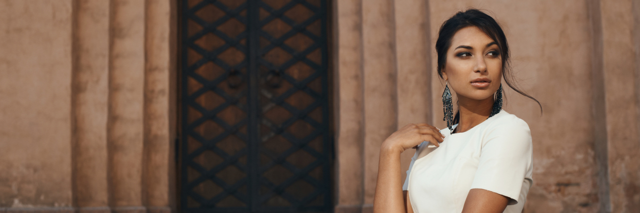 An woman standing outside of a building.