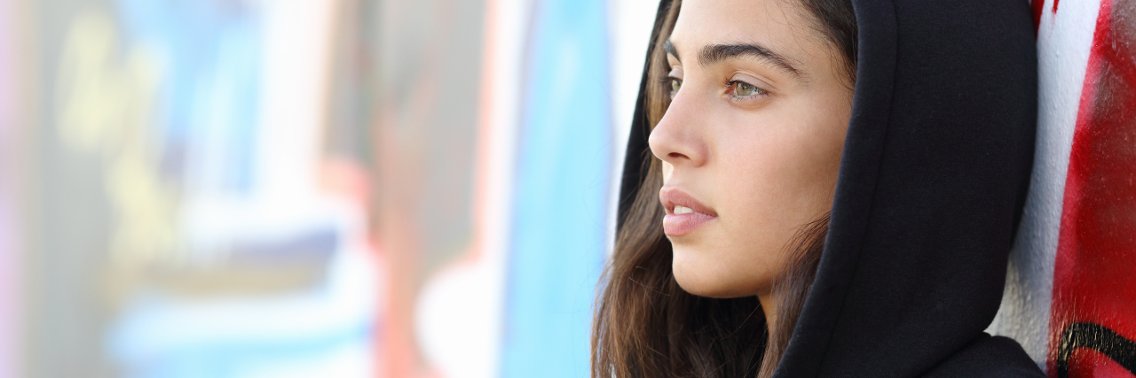 What I Want the People Who Tell Me 'You Don’t Look Depressed' to Know Profile portrait of a skater style teenager girl with an unfocused graffiti wall in the background