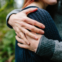 man with arms around woman