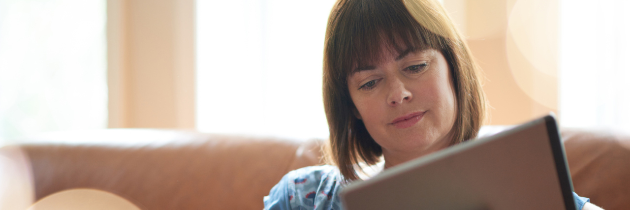 What I Keep in My Self-Care Toolbox for Chronic Pain Flares Woman reading on a tablet.