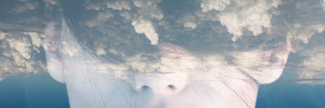 double exposure picture of a woman with clouds across her eyes