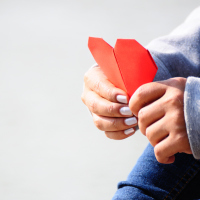 Hands Holding a Red Heart-Shaped Paper