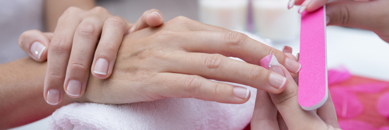 What Happened When I Told a Manicurist About My OCD Hand Washing close up of woman receiving manicure from beautician at nail salon