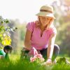 woman wearing pink shirt and hat gardening outside