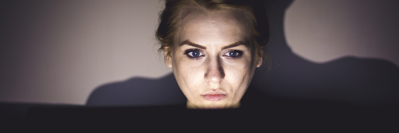 If You Believe Chronically Ill People Are Scammers A woman on her laptop late at night.