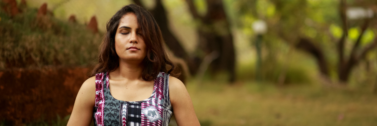 When You Become Ill and Words of Empowerment Begin to Fail A woman meditating in nature.