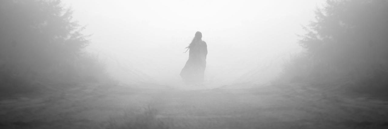 A photo of a person standing in the midst of fog.