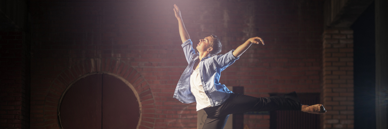 How Fibromyalgia Tried to Take Away My Greatest Love A woman dancing in front of an urban background.