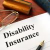 Disability insurance on a office table with a pen.