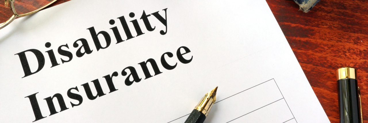 Why Applying for Disability Is Difficult Disability insurance on a office table with a pen.