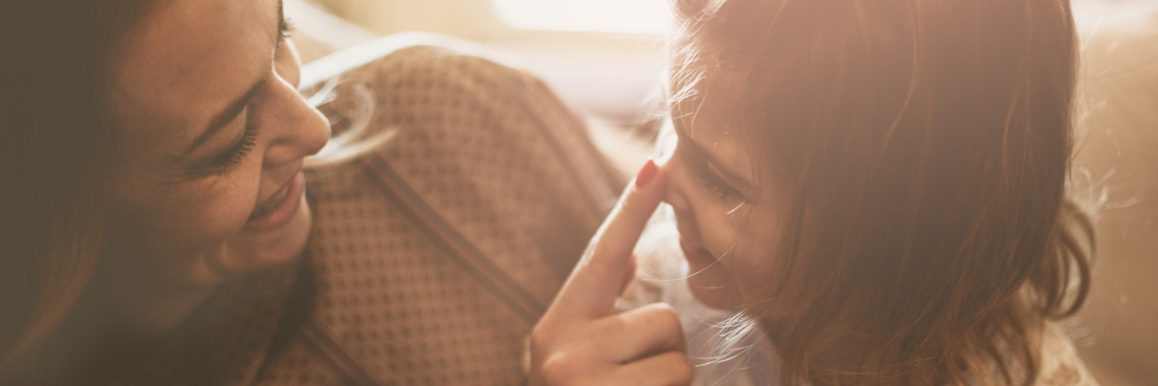What It's Like Having POTS and Raising Kids Mother and daughter are having fun at home. Mother touching daughter's nose.