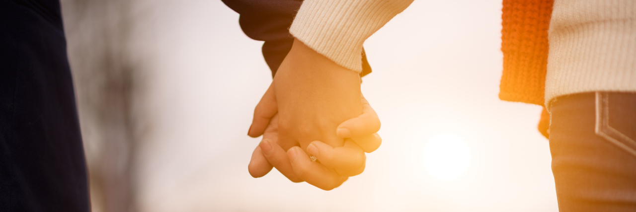 Why My Partner Stays With Me as Someone With Chronic Illness man and woman walking outside and holding hands