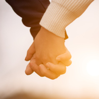 man and woman walking outside and holding hands