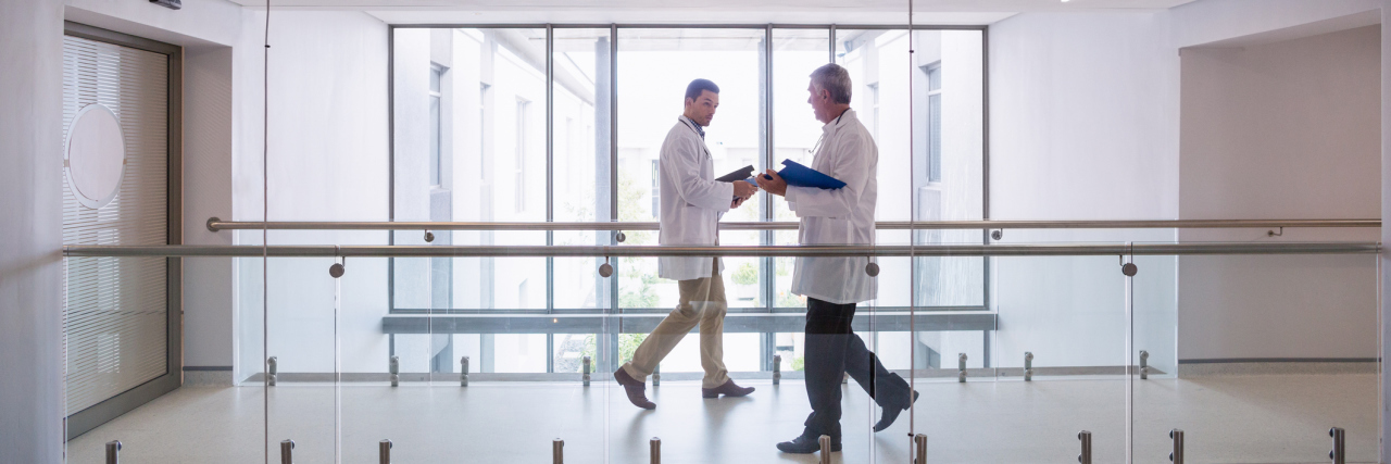 When It Takes Trial and Error to Find the Right Doctor Two doctors walking down a hospital pathway.