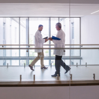 Two doctors walking down a hospital pathway.